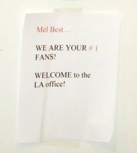 A handwritten sign that reads: Mel Best, WE ARE YOUR #1 FANS! WELCOME to the LA office.